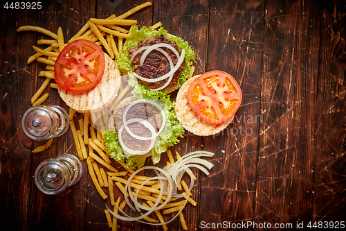 Image of Two tasty grilled home made burgers with beef, tomato, onion and lettuce