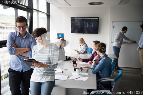 Image of Two Business People Working With Tablet in office