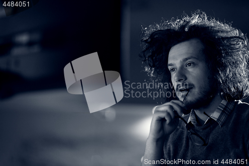 Image of man working on computer in dark office