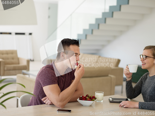 Image of couple enjoying morning coffee and strawberries