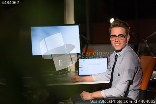 Image of man working on computer in dark office