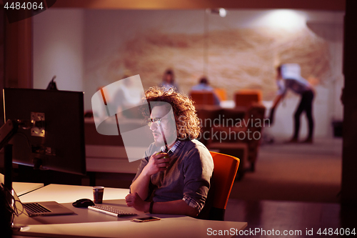 Image of man working on computer in dark office