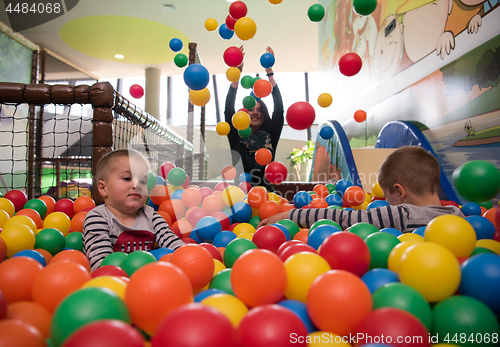 Image of Young mom with her kids in a children\'s playroom