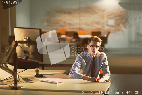 Image of man working on computer in dark office