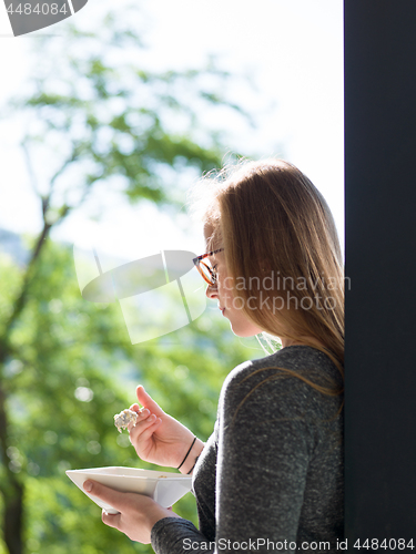 Image of woman eating breakfast in front of her luxury home villa