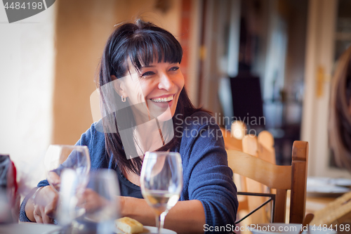 Image of Pretty Italian Woman Enjoys A Meal And Drinks with Friends at Ou