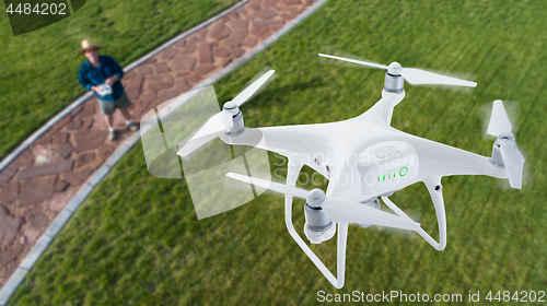 Image of Drone Quadcopter (UAV) In Air Above Pilot With Remote Controller