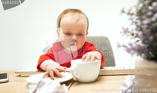 Image of Happy child baby girl toddler sitting with keyboard of computer isolated on a white background