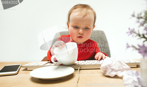 Image of Happy child baby girl toddler sitting with keyboard of computer isolated on a white background