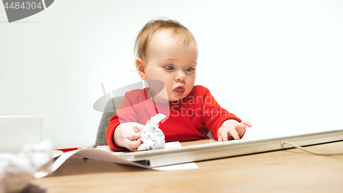 Image of Happy child baby girl toddler sitting with keyboard of computer isolated on a white background