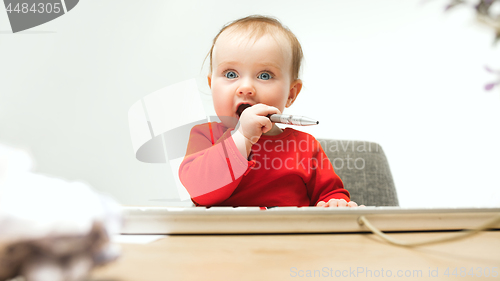 Image of Happy child baby girl toddler sitting with keyboard of computer isolated on a white background