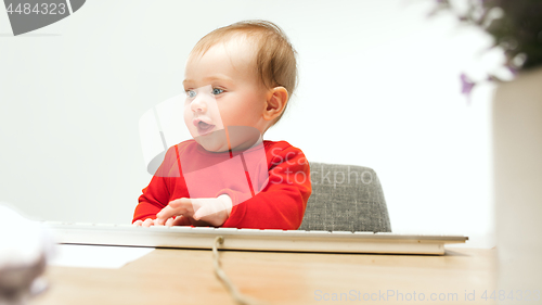 Image of Happy child baby girl toddler sitting with keyboard of computer isolated on a white background