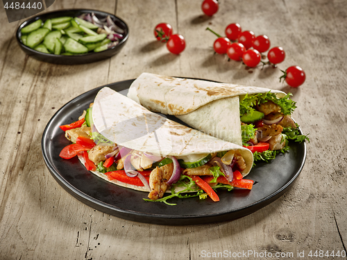 Image of Tortilla wraps with fried chicken meat and vegetables