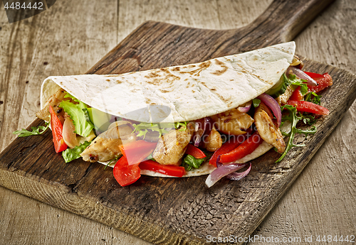 Image of Tortilla wrap with fried chicken meat and vegetables