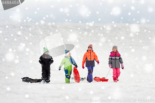 Image of happy little kids with sleds sledging in winter