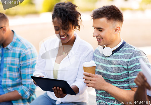 Image of happy friends with tablet pc and coffee outdoors