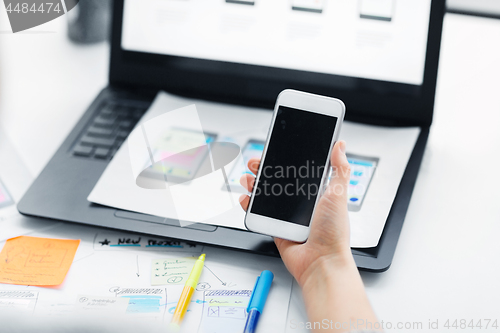 Image of web designer working on smartphone user interface