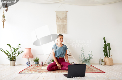 Image of woman with laptop computer at yoga studio