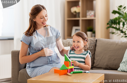 Image of pregnant mother and daughter with toy blocks