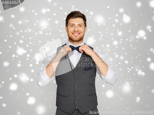 Image of happy man in festive suit dressing for party