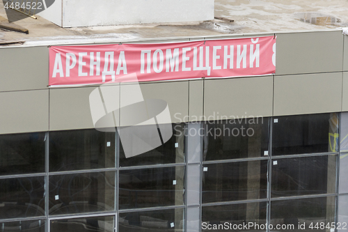 Image of Shabby sign \"rental of premises\" on the facade of the new shopping center