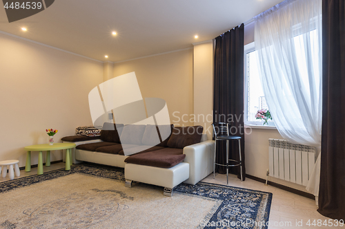 Image of Living room interior, large sofa and window with dark curtains