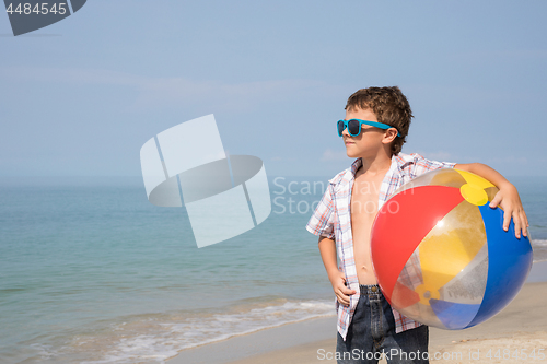 Image of One happy little boy playing on the beach at the day time.