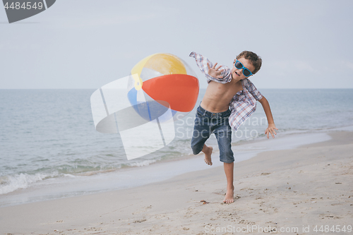 Image of One happy little boy playing on the beach at the day time.