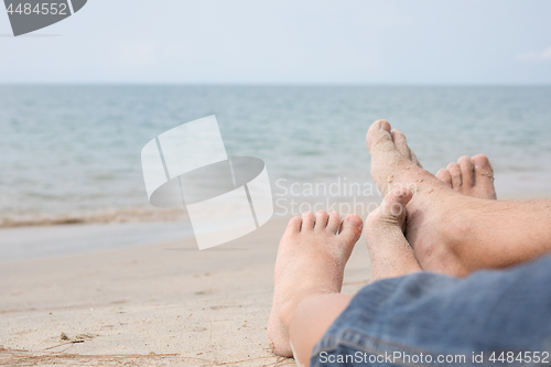 Image of Father and son playing on the beach at the day time.