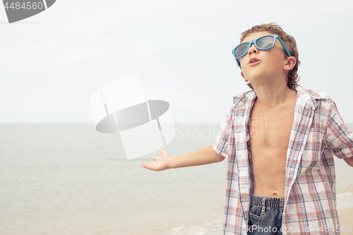 Image of One happy little boy playing on the beach at the day time.