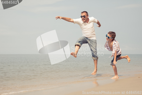 Image of Father and son playing on the beach at the day time.