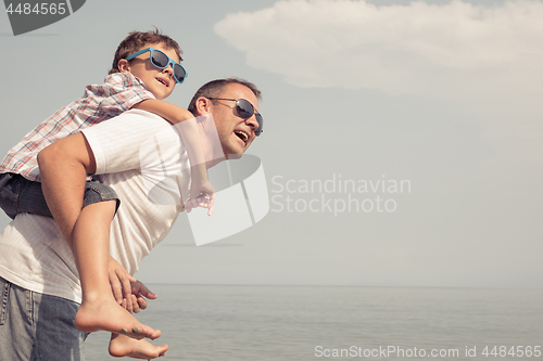 Image of Father and son playing on the beach at the day time.