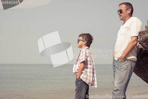 Image of Father and son playing on the beach at the day time.