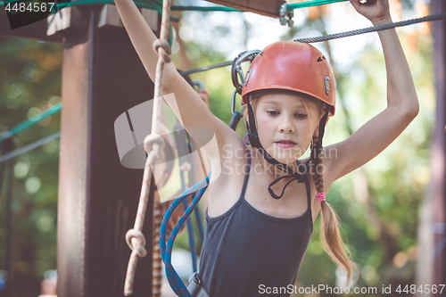 Image of little brother and sister make climbing in the adventure park.