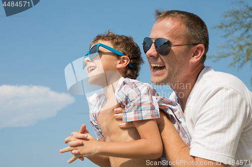 Image of Father and son playing on the beach at the day time.