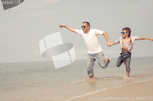 Image of Father and son playing on the beach at the day time.