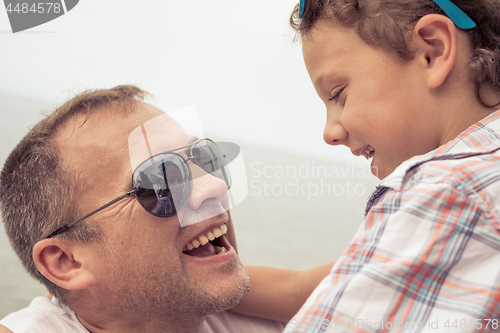 Image of Father and son playing on the beach at the day time.