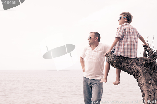 Image of Father and son playing on the beach at the day time.