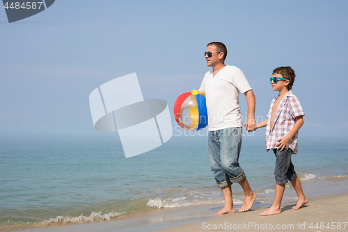 Image of Father and son playing on the beach at the day time.