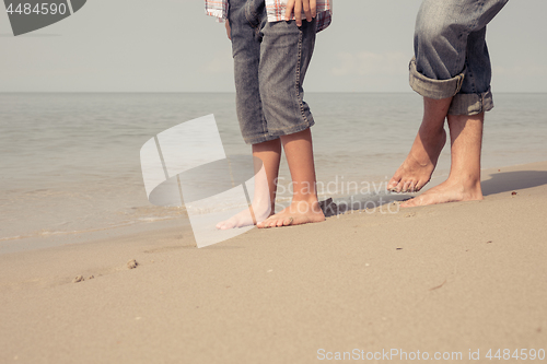 Image of Father and son playing on the beach at the day time.