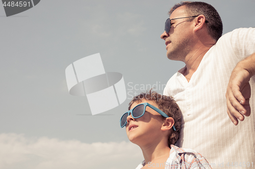 Image of Father and son playing on the beach at the day time.