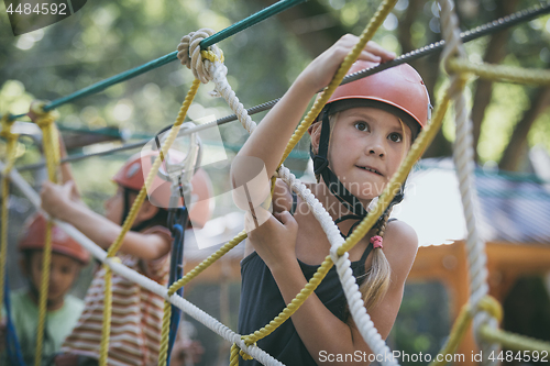 Image of little brother and sister make climbing in the adventure park.