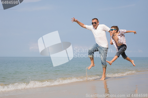 Image of Father and son playing on the beach at the day time.