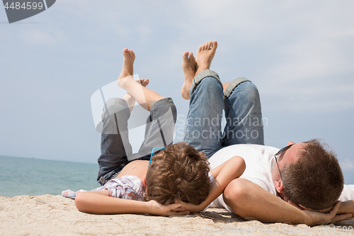 Image of Father and son playing on the beach at the day time.