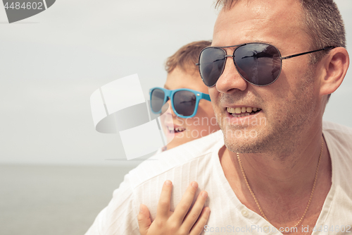 Image of Father and son playing on the beach at the day time.