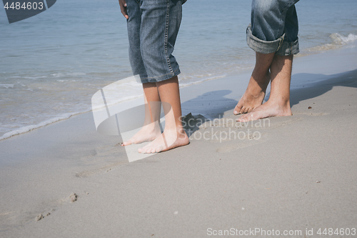 Image of Father and son playing on the beach at the day time.