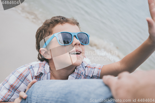 Image of Father and son playing on the beach at the day time.