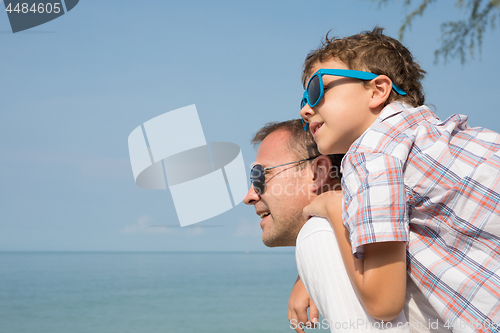 Image of Father and son playing on the beach at the day time.