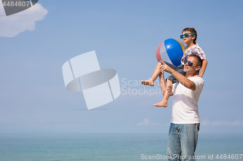 Image of Father and son playing on the beach at the day time.