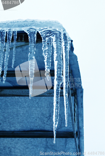 Image of Big icicles hanging from the roof at the corner of the building